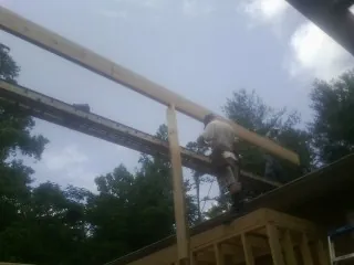 Carpenter setting a ridge beam over a new addition frame — Ice Dam Removal by Roofing Brothers in Castle Dale