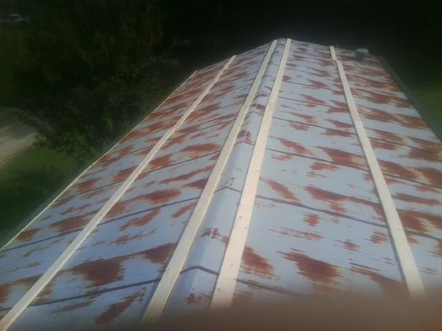 Rusted metal roof panels with new wood purlins before replacement — Storm Damage Roof Repair in Castle Dale by Roofing Brothers