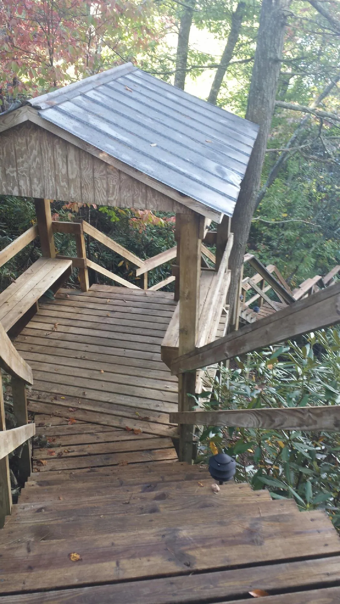 Metal roofed shelter over wooden steps on a wooded walkway — Skylight Repair & Installation work by our crew in Castle Dale