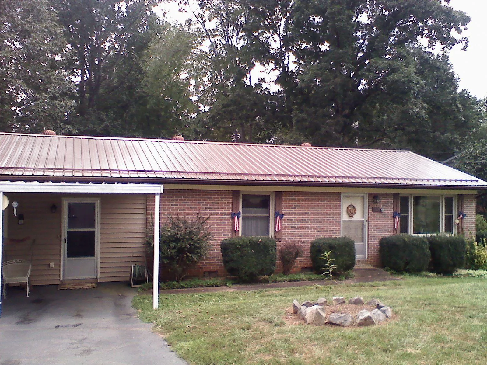 Bronze metal roof and carport on a brick ranch home — Roof Repair work by our crew in Castle Dale